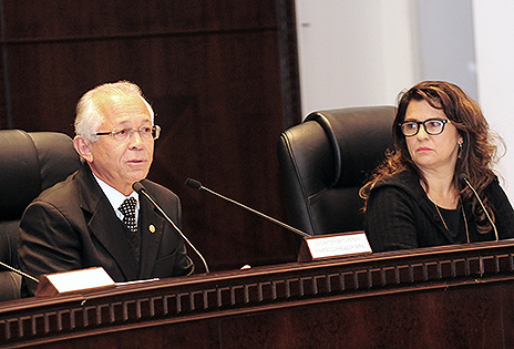 Foto mostra bancada principal do plenário Pedro Ribeiro tavares, onde ocorreu a sessão de leitura da ata de correição ordinária realizada no TRT-PR. Em primeiro plano, falando ao microfone para a plateia, é possível ver o corregedor-geral da Justiça do Trabalho, ministro João Batista Brito Pereira. Sentada na poltrona ao lado, olhando para o ministro, a diretora da Corregedoria-Geral da Justiça do Trabalho, Coelis Maria Araújo Martins