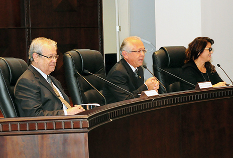 Foto em plano médio mostra, em ângulo aproximado de 45 graus, a bancada principal do plenário Pedro Ribeiro Tavares, na sede do TRT-PR, ocupada, a partir da esquerda, pelo desembargador presidente do Tribunal Regional do Trabalho do Paraná, Altino Pedrozo dos Santos; o corregedor-geral da Justiça do Trabalho, ministro João Batista Brito Pereira; e a diretora da Corregedoria-Geral da Justiça do Trabalho, Coelis Maria Araújo Martins. O ministro dirige-se ao público pelo microfone. Os demais integrantes da bancada estão olhando para a plateia