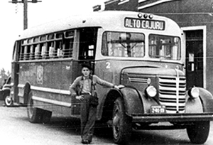 Foto histórica traz trabalhador em frente a ônibus que tem como rota o "Alto Cajuru".