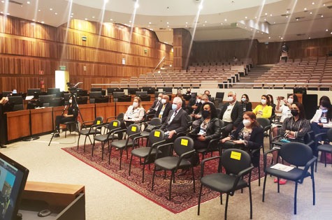 Integrantes do Coleouv assistem a apresentação, no plenário onde foi realizada a reunião do Conselho. Foto tomada lateralmente, com os desembargadores do Conselho em cadeiras, no centro do plenário, que tem forma de arena.