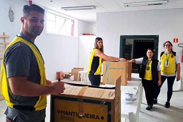 Voluntários separam os materiais para doação em caixas.