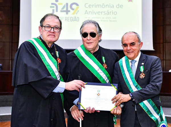 Fotografia de três homens em pé, lado a lado, segurando um certificando. Os três bestem toga e uma faixa verde e branca, da Ordem das Araucárias