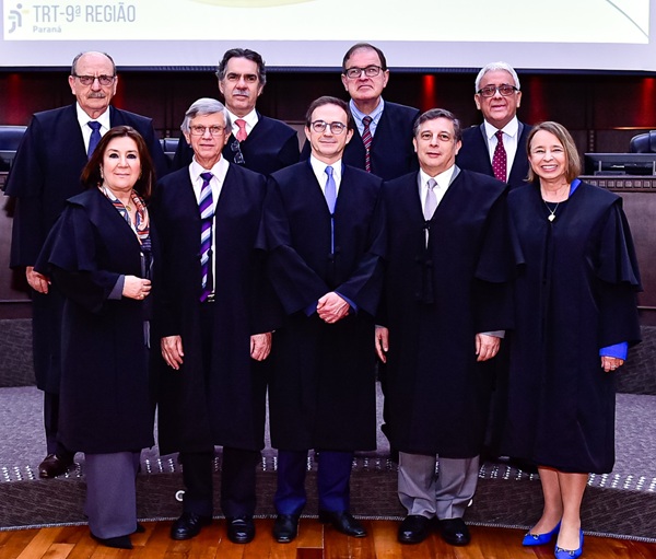 fotografia de um grupo de nove pessoas perfiladas com quatro homens atrás e três homens e duas mulheres à frente.