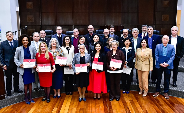 Fotografia de um grupo de cerca de trinta pessoas, perfiladas lado a lado em tr&ecirc;s linhas