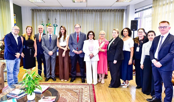 Fotografia de um grupo de 13 pessoas, com oito mulheres e cinco homens, perfilados lado a lado.