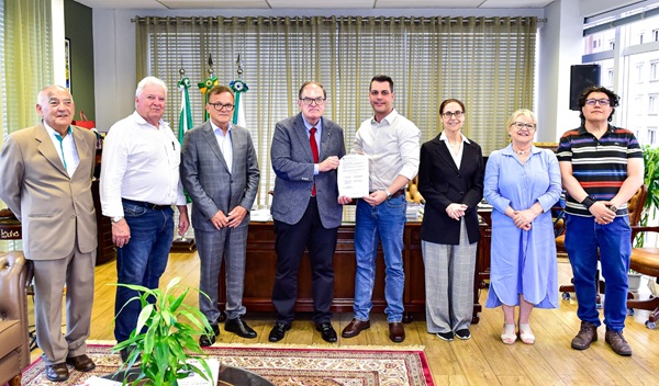 Fotografia de oito pessoas perfiladas lado a lado, sendo seis homens e duas mulheres