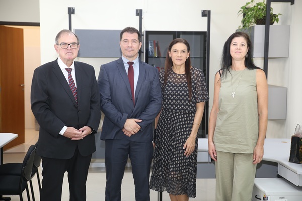 Fotografia de quatro pessoas em p&eacute;, lado a lado, sendo dois homens e duas mulheres. 